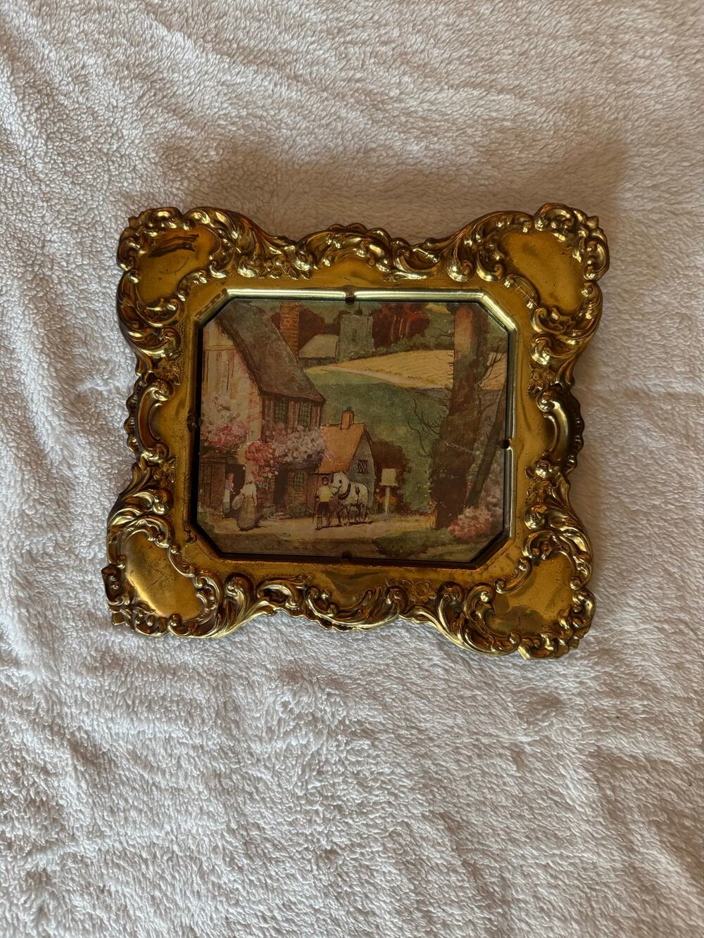 Vintage embossed brass frame with a foil print of an English countryside.